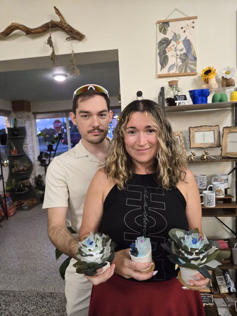 A couple holding their handmade succulent planters from a MyMakerScape workshop